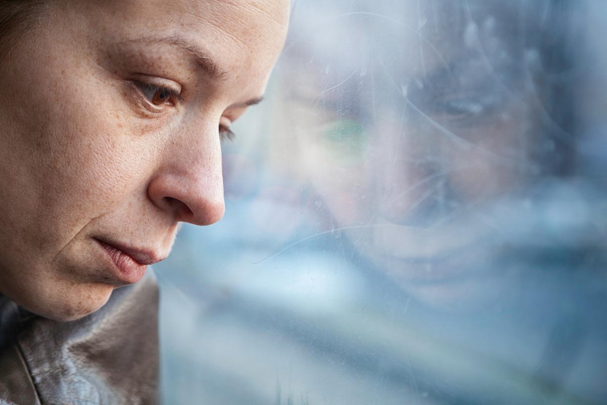 a person looks down out of a window possibly struggling with different types of depression