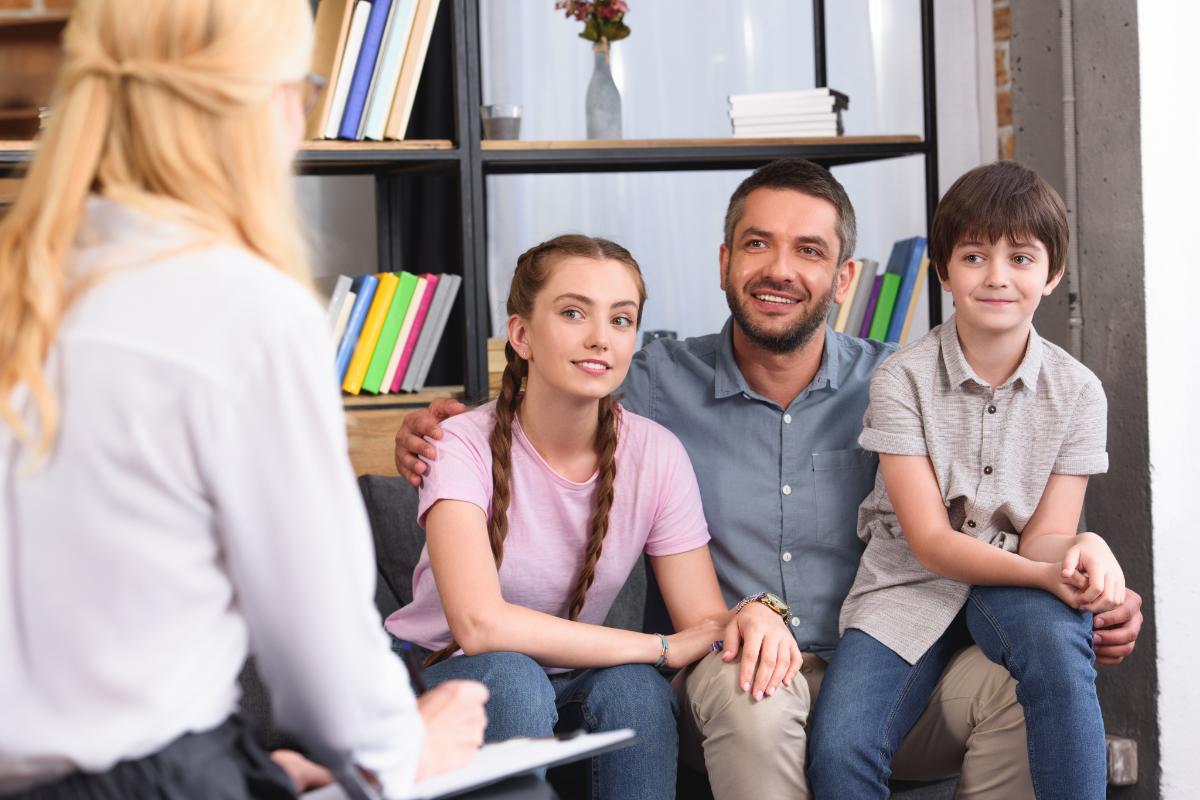 How To Set Family Therapy Goals two young people and a parent speak with a counselor about achieving family therapy goals