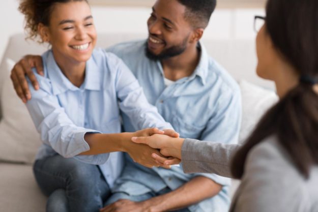 What is a Residential Treatment Program_ two people sit on a couch while one of them shakes hands with a counselor in a residential treatment program