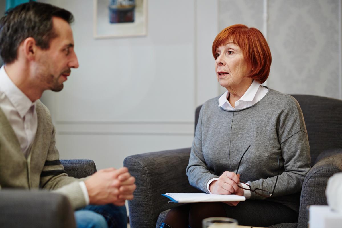 counselor explaining benefits of pharmacotherapy to patient during session