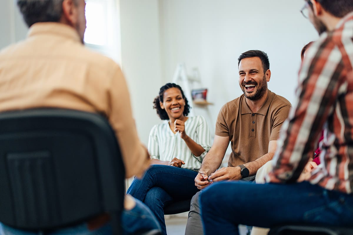 a group of people sit in a circle and talk during a residential treatment center in altoona pa