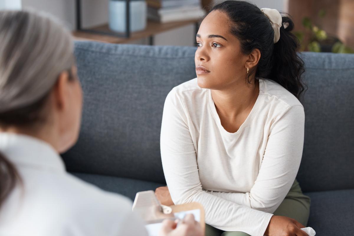 Benefits of an Anxiety Treatment Center a person looks forlorn while sitting on a couch and learning about the benefits of an anxiety treatment center